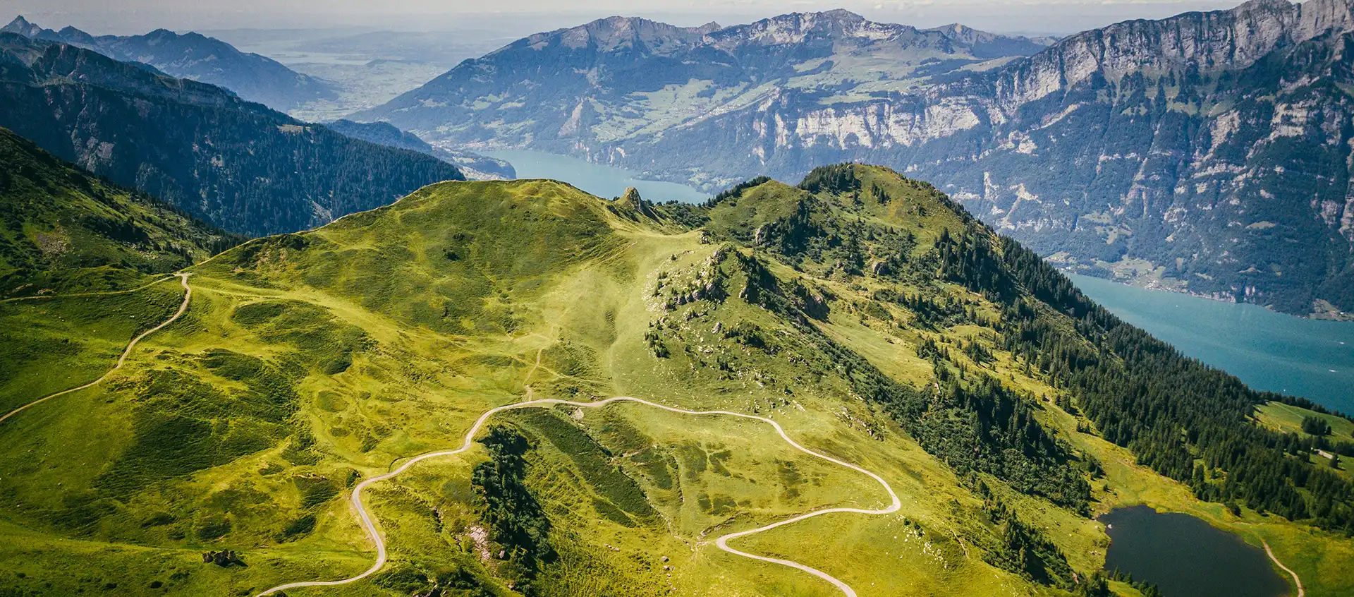 Aerial view of mountains in Flumserberg, Flums, Switzerland with trails and lake in the background